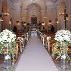 the aisle is decorated with white flowers and greenery for an elegant wedding ceremony at st mary's church