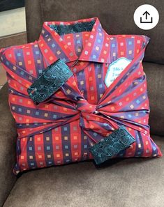 a pillow with a bow on it sitting on a couch next to a brown chair