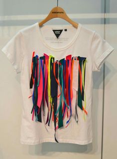 a white t - shirt with multicolored ribbons hanging from it's chest