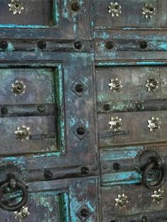 an old metal door with many knobs and rivets on the front side