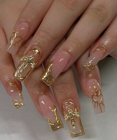 a woman's nails with gold decorations on them