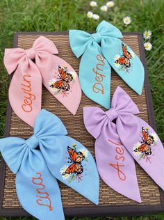 four different colored hair bows with the words, yes and no on them in front of some daisies