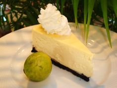 a piece of cheesecake on a plate with a lime