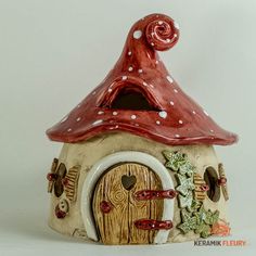 a ceramic house with a red roof and white polka dots on it's top