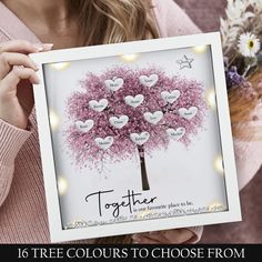 a woman holding up a card with the words together on it and a tree made out of hearts