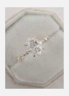 a diamond ring sitting on top of a cushion