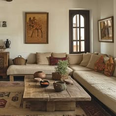 a living room filled with lots of furniture next to a wooden coffee table in front of a window