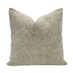 a white pillow with silver flowers on the front and back, against a white background