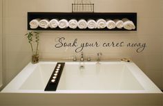 a white bath tub sitting next to a shelf filled with towels