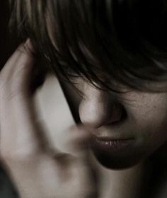 a close up of a person holding their hand to his ear and talking on the phone