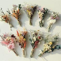 an assortment of dried flowers laid out on a white surface