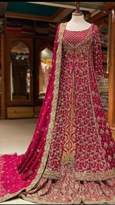 a mannequin dressed in a red and gold lehenga