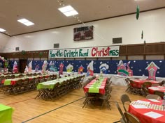 tables and chairs are set up for christmas dinner in the gym with decorations on the wall