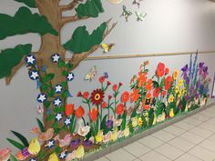 the wall is decorated with colorful flowers and butterflies, along with a tree that has been painted on it