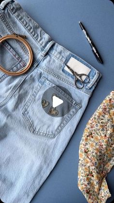 a pair of scissors and some clothes on a blue surface with a flowery bow tie