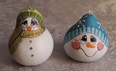 two ceramic snowmen sitting next to each other