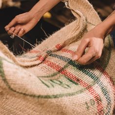 a person is sewing on a piece of burlock that has been made into a bag