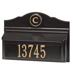 a black and gold mailbox with the letter c on it