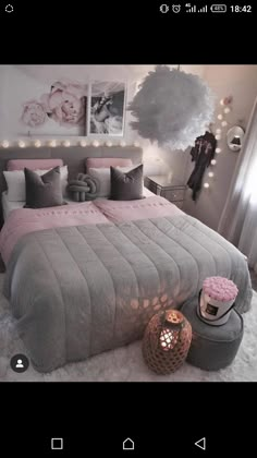 a bedroom decorated in gray and pink with lights