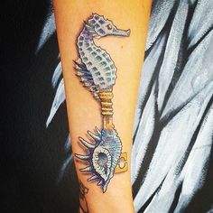 a sea horse tattoo on the arm