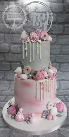 a three tiered cake with pink and grey decorations