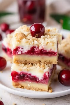 three pieces of cake on a plate with cherries