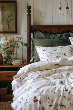 a bed with white sheets and green comforter in a room next to a dresser