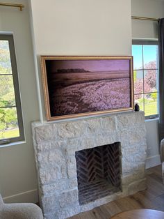 a living room with a fire place in the corner and a painting on the wall