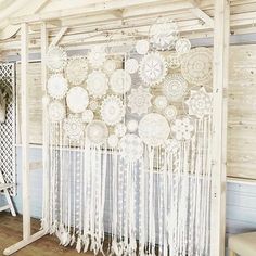 a white curtain with fringes hanging from it's side in front of a wooden wall