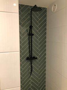 the shower head is mounted to the side of the wall in this bathroom with herringbone tile