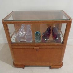 a display case with various pairs of shoes in glass on the top and bottom shelf