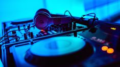 a turntable with an old fashioned record player in the foreground and blue light behind it