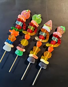 several gummy bears are sitting on top of candy lollipops in the shape of animals