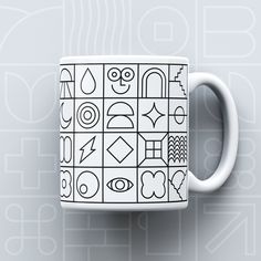 a coffee mug with black and white designs on it's side against a gray background