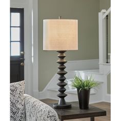 a lamp that is on top of a table next to a pot with a plant