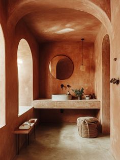 a bathroom with an oval mirror above the sink and a bench in front of it