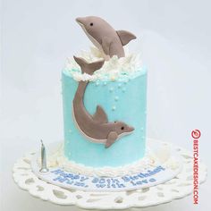 a blue and white cake with two dolphins on it