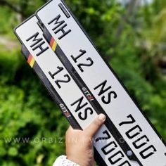 a person holding two street signs in their hand