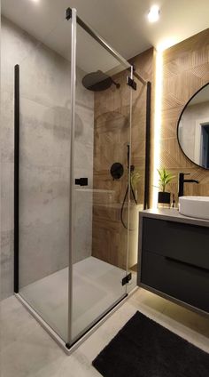 a bathroom with a walk in shower next to a sink and mirror on the wall