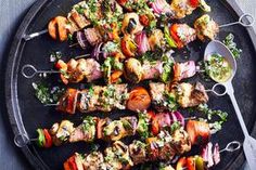 several skewered meats and vegetables on a platter