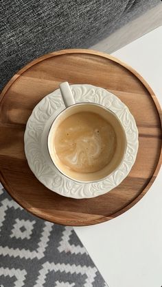 a cup of coffee sitting on top of a wooden tray