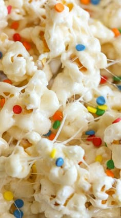 white popcorn with sprinkles and colored candies on the top is ready to be eaten