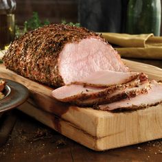 a sliced ham on a cutting board next to a knife