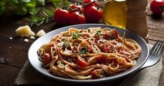 a plate of pasta with tomatoes and parmesan cheese