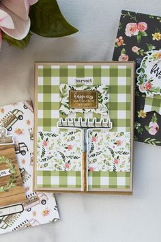 some cards are laying next to each other on a table with pink flowers and green checkered paper