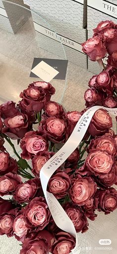 a bunch of flowers that are on top of a glass table with a ribbon around it