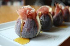 figs on a white plate with mustard drizzled over them and some sort of appetizer