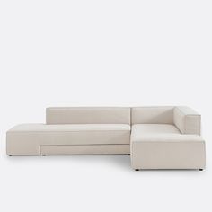 a white sectional couch sitting on top of a white floor