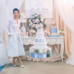 a woman standing next to a table with a large cake on it's side