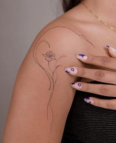 a woman's arm with tattoos on it and flowers painted on the back of her arm